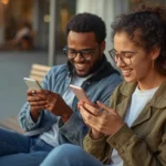 “Two friends smiling while texting on their phones, showing a casual conversation that represents what does cuh mean in modern slang usage.”
