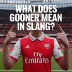 Soccer fan wearing a red jersey pointing upward in a stadium with text “What Does Gooner Mean in Slang?”, representing the slang term used for fans of Arsenal Football Club.
